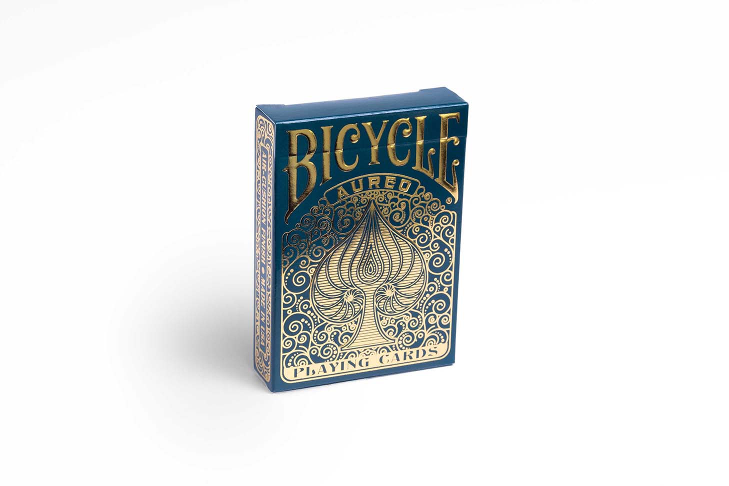 Eine Bicycle Creatives Aureo Kartenschachtel steht mit sichtbarer Vorderseite vor einem weißem Hintergrund.