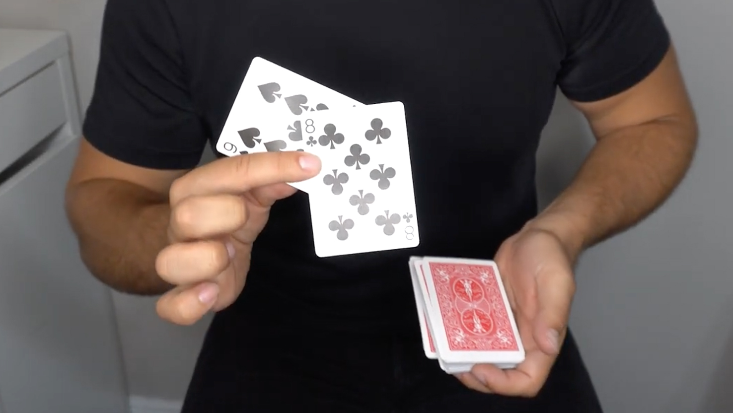 Das Beitragsbild für das Tutorial Video für den Boss Zaubertrick zeigt eine Person, die eine Pik Acht und eine Pik Neun in der Hand hält.