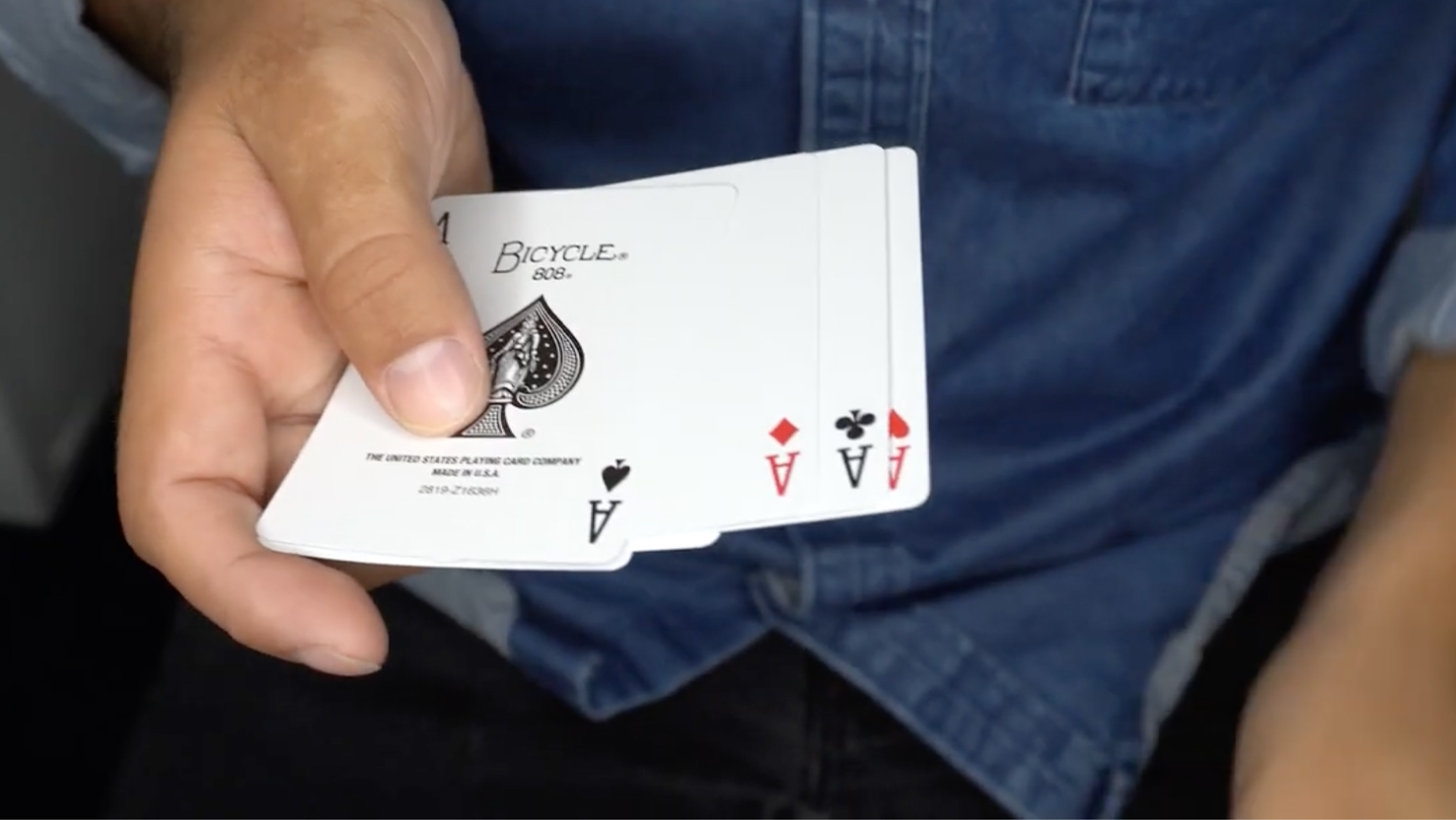 Das Beitragsbild für das Tutorial Video für den Zapped Zaubertrick zeigt eine Person die alle vier Ass Karten in der Hand hält.