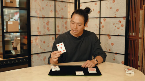 Das Beitragsbild für das Tutorial Video für diesen simplen Zaubertrick mit großer Wirkung zeigt den Zauberkünstler Yuta, der eine Herz Drei Karte in der Hand hält.