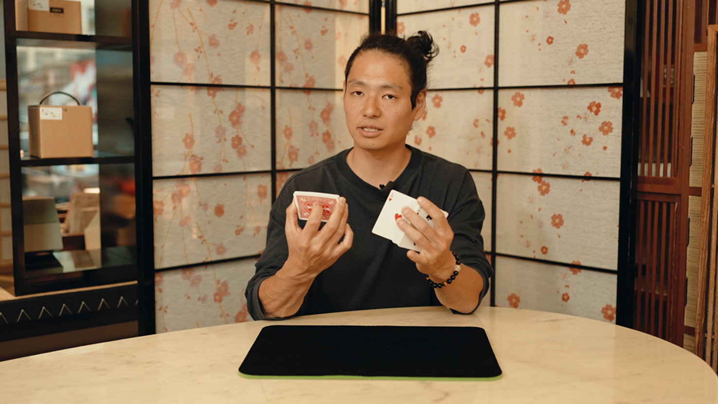 Das Beitragsbild für das Tutorial Video für diesen Bar Zaubertrick zeigt den Zauberkünstler Yuta, der Karten in den Händen hält.
