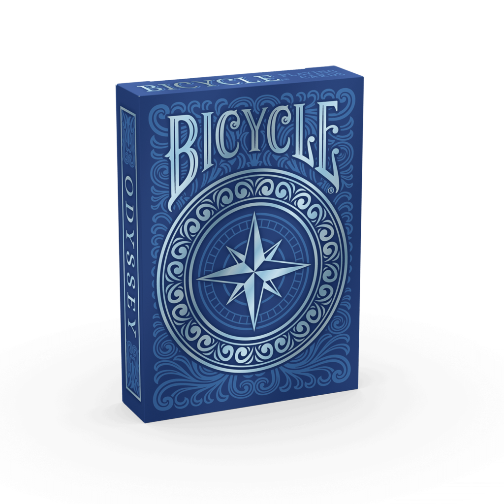 Eine Bicycle Creatives Odyssey Kartenschachtel steht mit sichtbarer Vorderseite vor einem weißem Hintergrund.