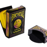 Die Bicycle Creatives Smiley André Kartenschachtel steht geöffnet vor einem weißen Hintergrund. Der ausklappbare Smiley ist sichtbar.