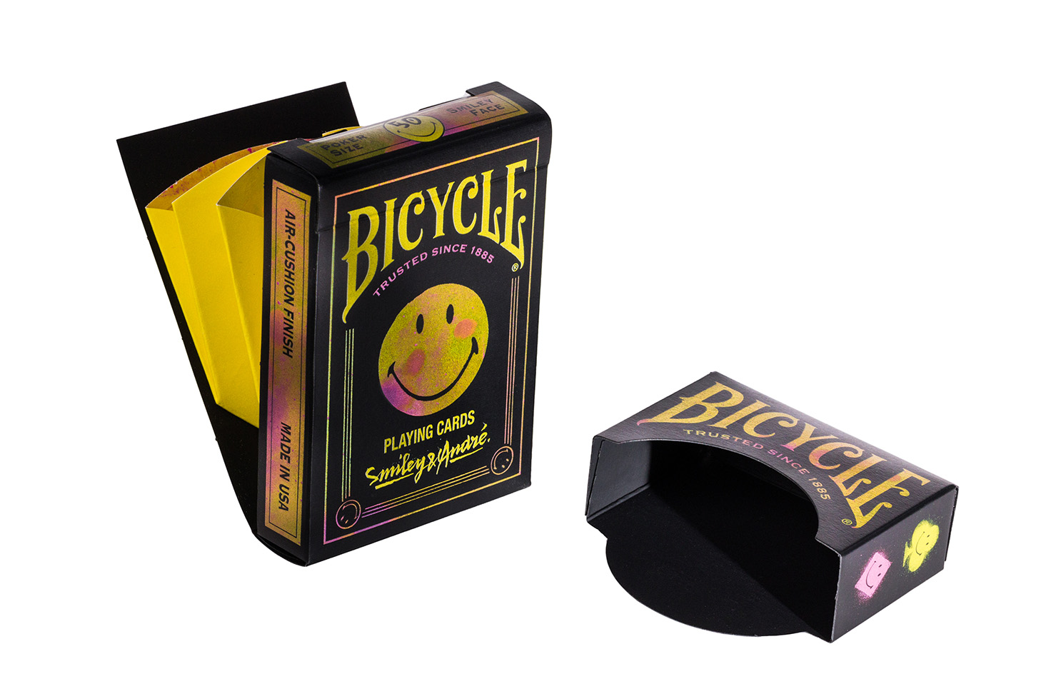Die Bicycle Creatives Smiley André Kartenschachtel steht geöffnet vor einem weißen Hintergrund. Der ausklappbare Smiley ist sichtbar.
