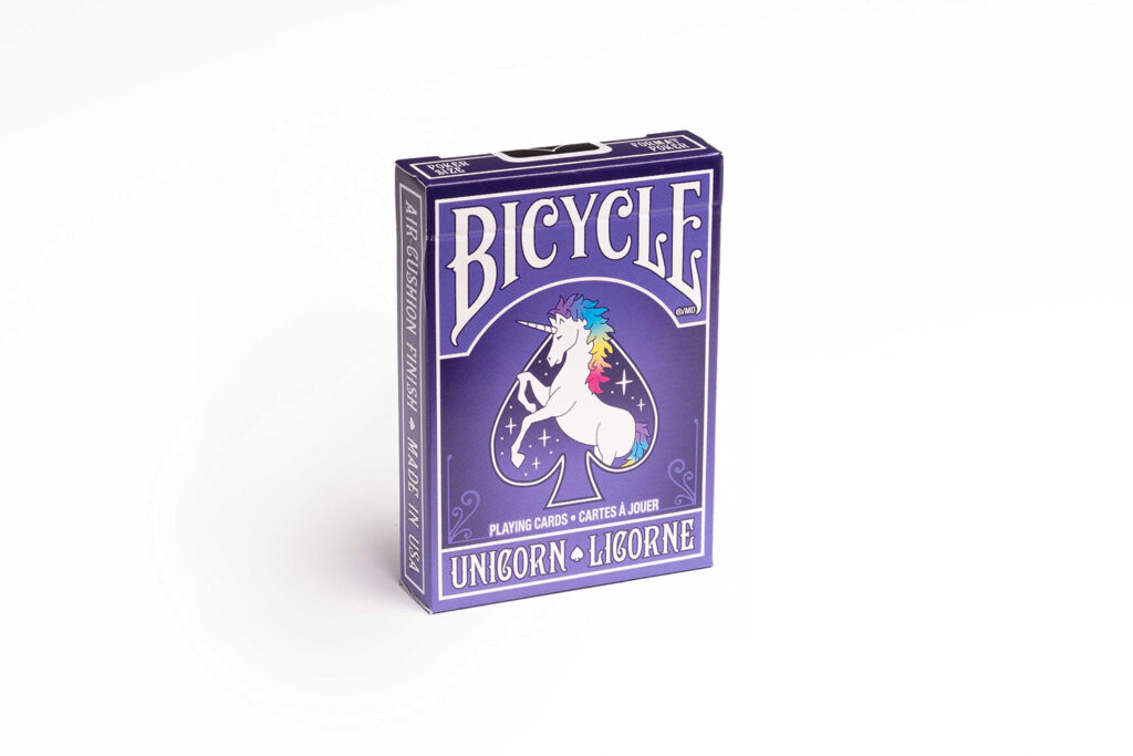 Eine Bicycle Creatives Unicorn Kartenschachtel steht mit sichtbarer Vorderseite vor einem weißem Hintergrund.