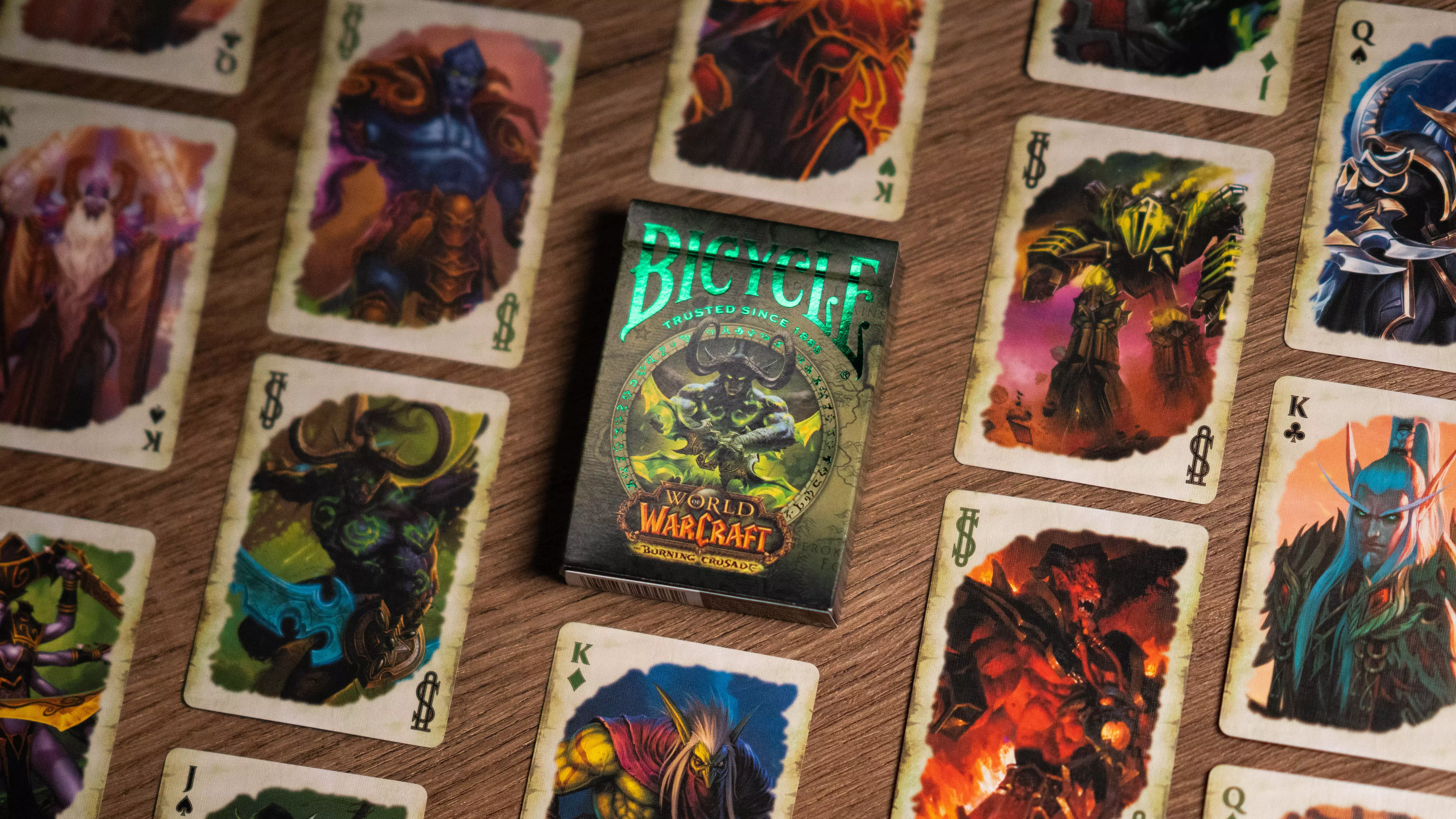Eine Bicycle Creatives Bicycle World of Warcraft Burning Crusade Kartenschachtel liegt auf einem Holztisch Hintergrund, neben der Schachtel liegen die Karten aus dem Deck.