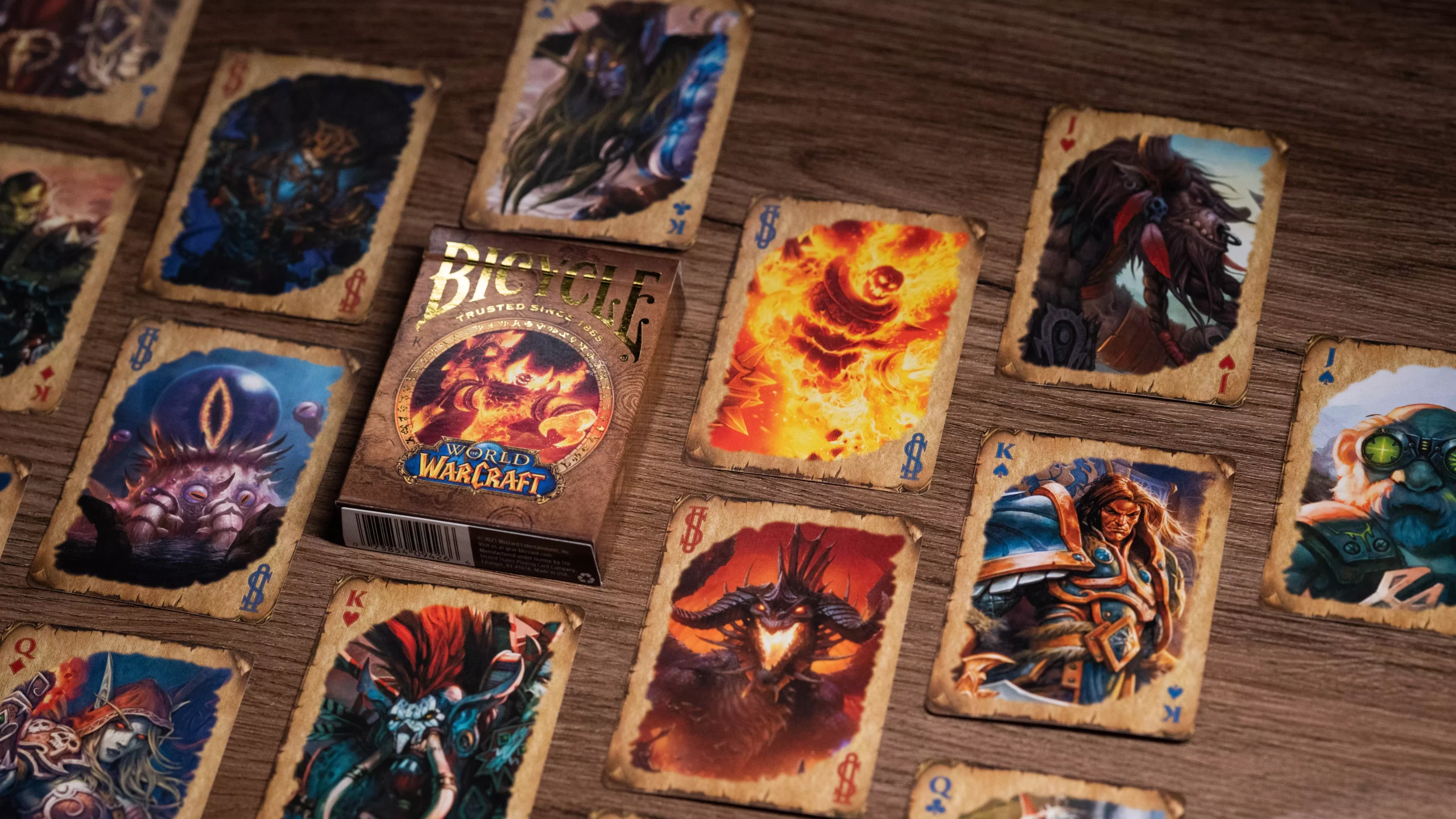 Eine Bicycle Creatives Bicycle World of Warcraft Classic Kartenschachtel liegt auf einem Holztisch Hintergrund, neben der Schachtel liegen die Karten aus dem Deck.