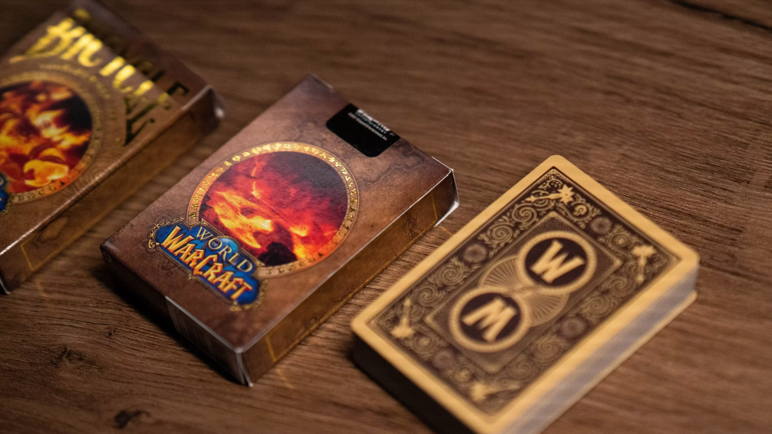 Eine Bicycle Creatives Bicycle World of Warcraft Classic Kartenschachtel liegt auf einem Holztisch Hintergrund, neben der Schachtel liegt ein Kartenstapel aus dem Deck.