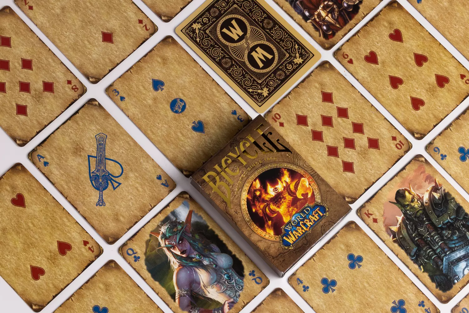 Eine Bicycle Creatives Bicycle World of Warcraft Classic Kartenschachtel liegt auf einem weißem Hintergrund, neben der Schachtel liegen die Karten aus dem Deck.