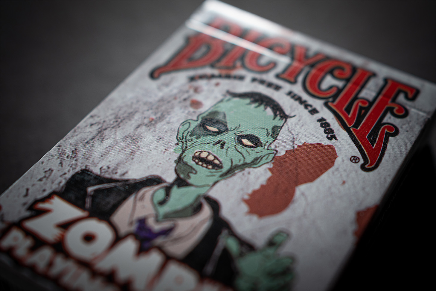 Zu sehen ist eine Detailaufnahme der Premium-Zombie-Spielkarten von Bicycle. Diese edlen Bicycle® Zombie eignen sich perfekt für Zaubertricks, Magie und gute Kartenspiele. Das Design der Schachtel ist perfekt für Halloween und Zombie-Themenpartys geeignet.