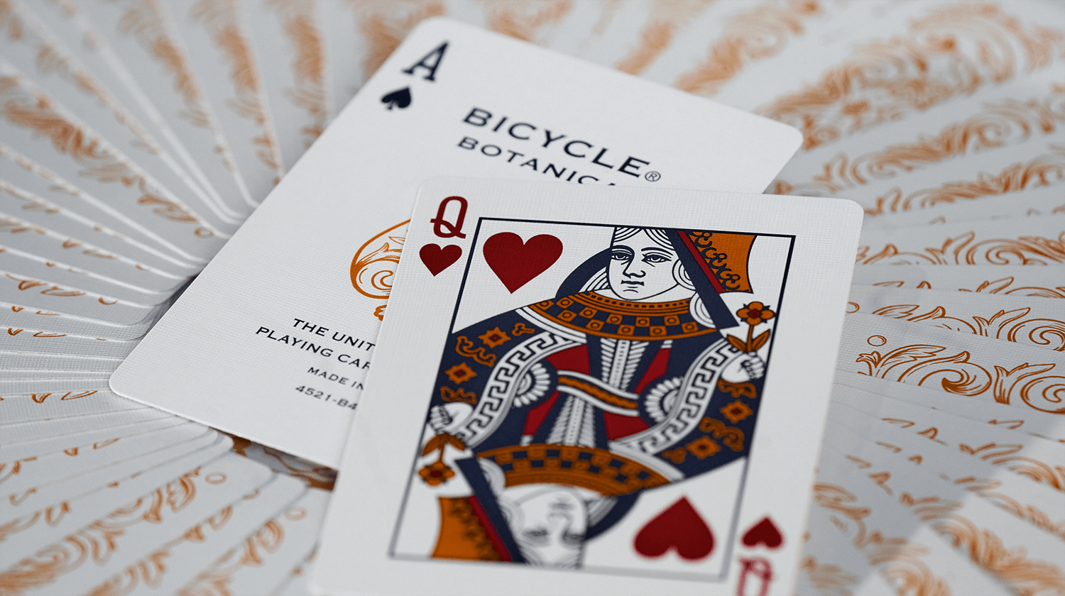 Zwei Karten der Bicycle Creatives Botanica liegen auf einem Hintergrund aus Kartenrückseiten.