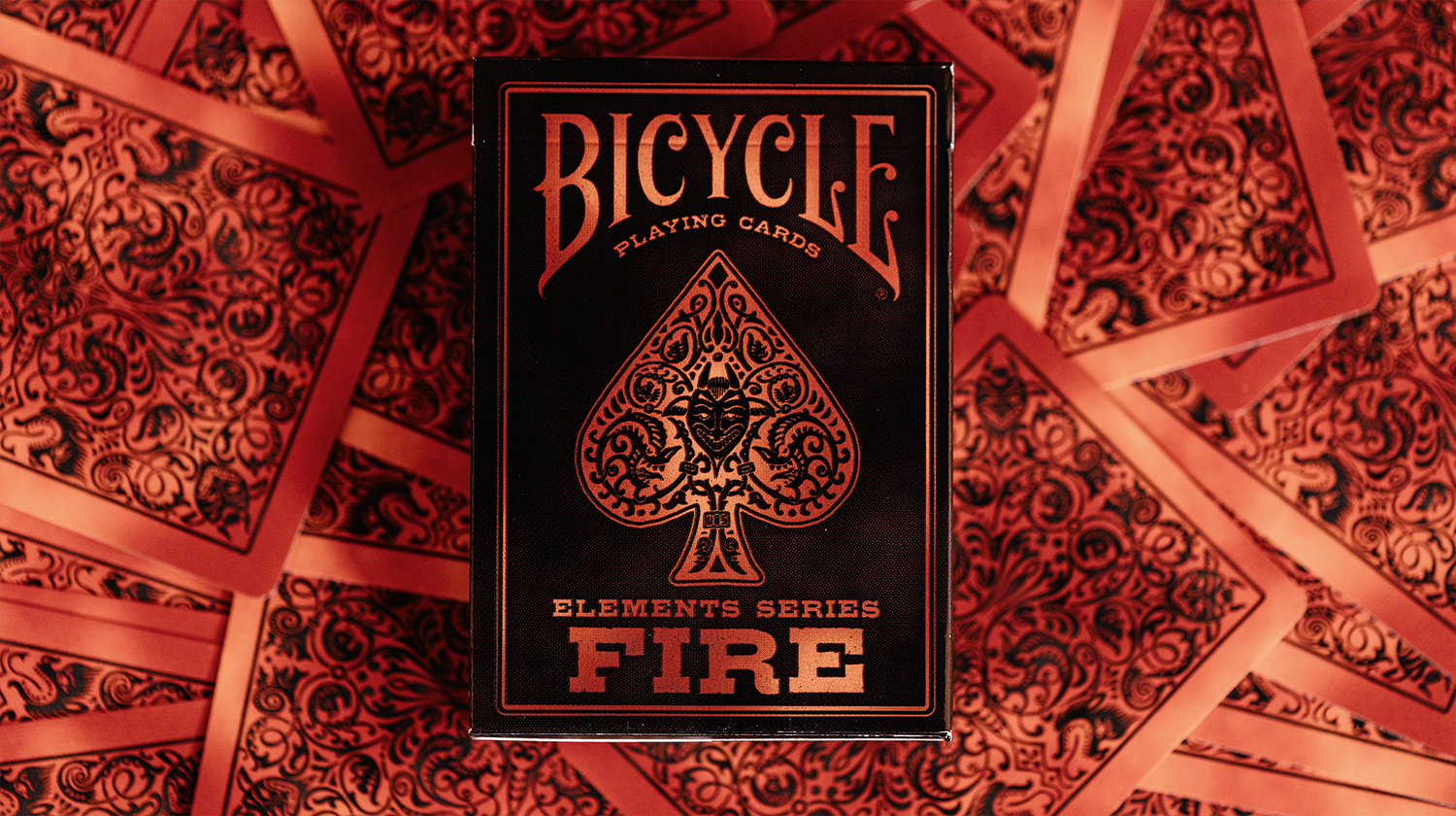 Eine Bicycle Creatives Fire Kartenschachtel liegt auf einem Hintergrund aus Kartenrückseiten.