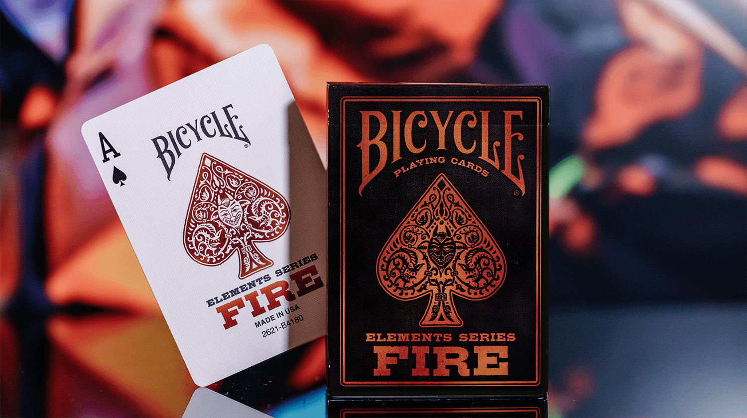 Von einer Bicycle Creatives Fire Kartenschachtel ist die Vorderseite zu sehen, daneben ist die Vorderseite einer Karte zu sehen.
