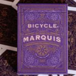 Eine Schachtel aus einem Bicycle Creatives Marquis Kartendeck liegt auf einem Hintergrund aus Rückseiten des Decks.
