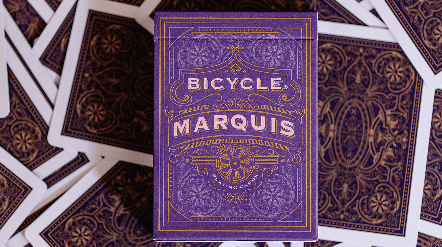 Eine Schachtel aus einem Bicycle Creatives Marquis Kartendeck liegt auf einem Hintergrund aus Rückseiten des Decks.