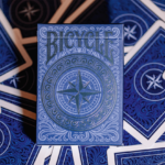 Eine Schachtel aus einem Bicycle Creatives Odyssey Kartendeck liegt auf einem Hintergrund aus Rückseiten des Decks.