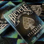 Eine Bicycle Creatives Stargazer Observatory Kartenschachtel liegt auf einem Stapel weiterer Schachteln.