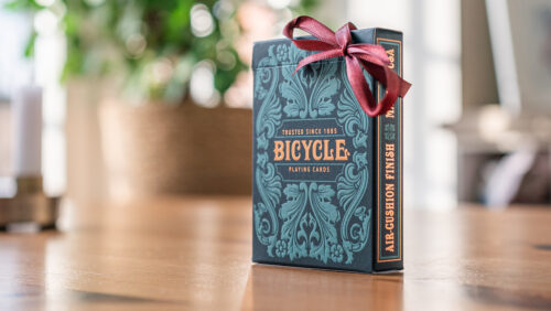 Ein Bicycle Creatives Sea King Kartendeck steht auf einem Holztisch als Geschenk verpackt mit einer Schleife.