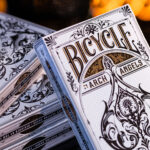 Eine Bicycle Creatives Archangels Kartenschachtel lehnt mit sichtbarer Vorderseite an einem Stapel Kartenschachteln mit sichtbarer Rückseite.
