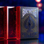 Vier Bicycle Ultimates Foil Back Cobalt Blue Kartenschachteln stehen vor einem dunklem atmosphärischem Hintergrund voreinander. Vorder und Rückseiten der Schachteln sind zu sehen.