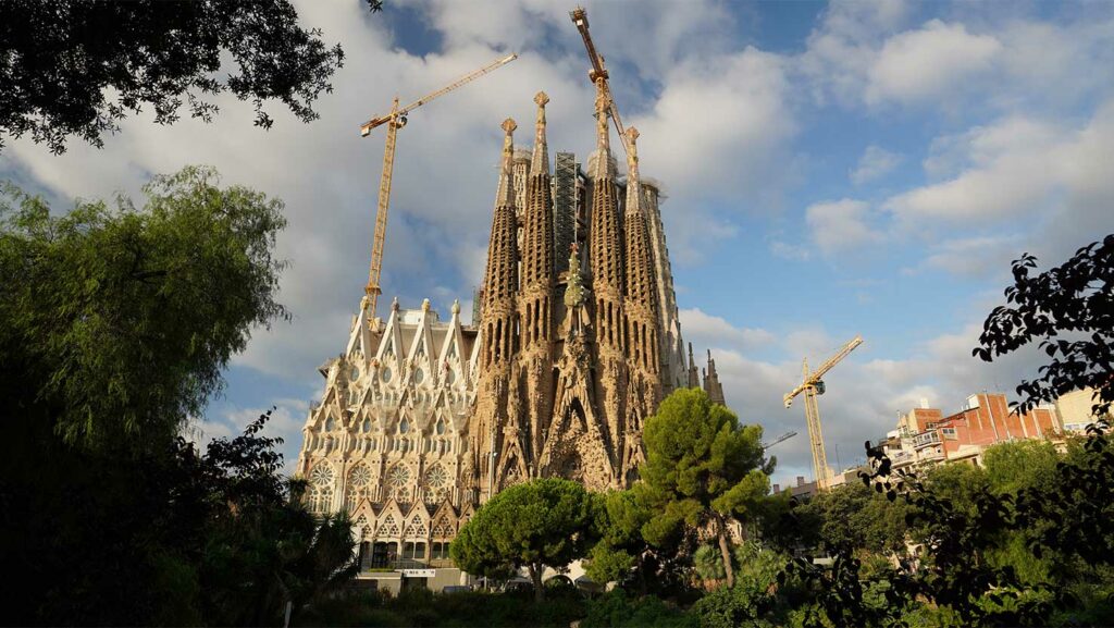 Blick durch die Bäume auf die Sagrada Familia in Barcelona. Berühmte Gebäude, Bicycle Spielkarten