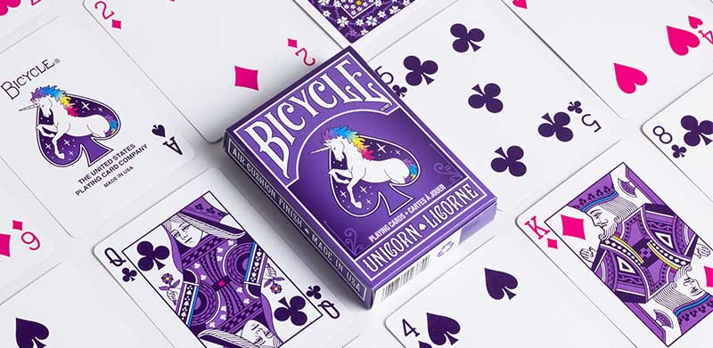 Das Kartenspiel Bicycle Unicorn liegt inmitten von Spielkarten. Einhorn-Spiele, Bicycle Spielkarten