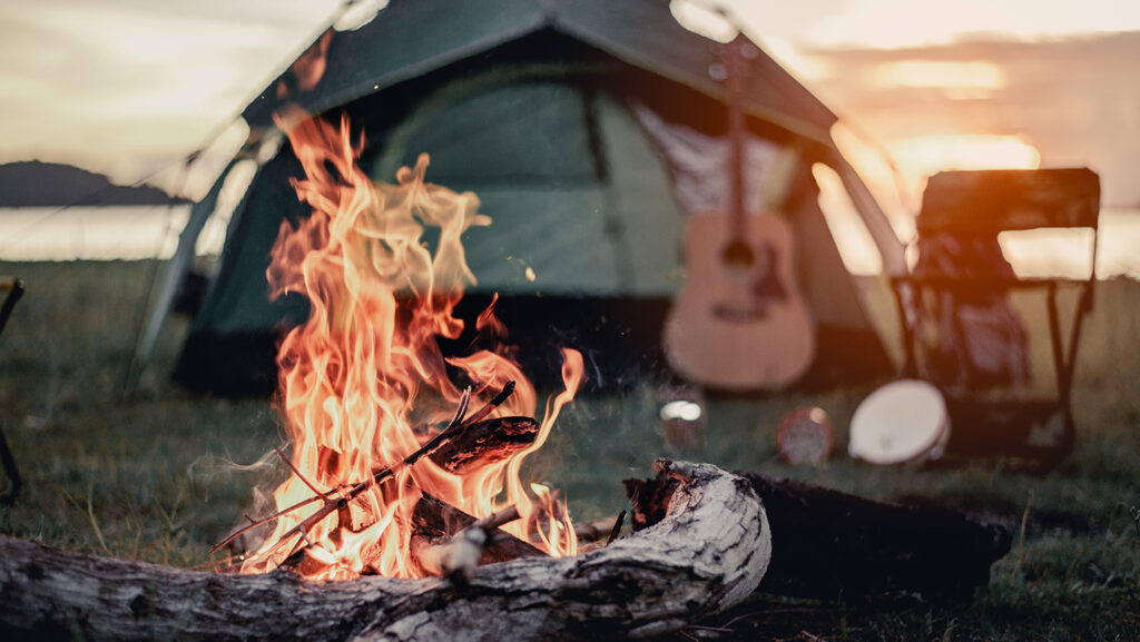 Lagerfeuer-Stimmung beim Zelten. Kartenspiele sind ein Camping-Must-Have.