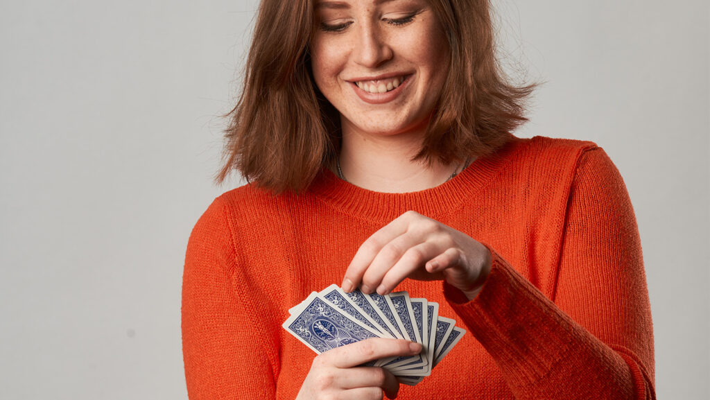 Eine junge Frau hat Spaß beim Kartenspiel.