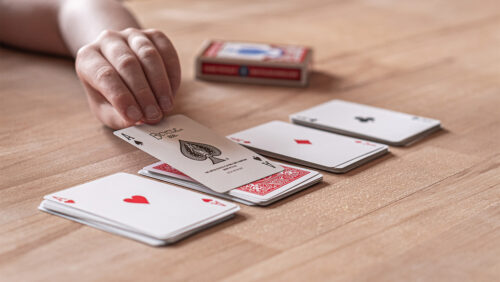 Ein Kind führt einen Zaubertrick auf und hat vier Kartenstapel vor sich liegen, deren jeweils oberste Karte ein ASS ist. Für diese einfachen Zaubertricks für Kinder braucht man nur ein Kartendeck von Bicycle.