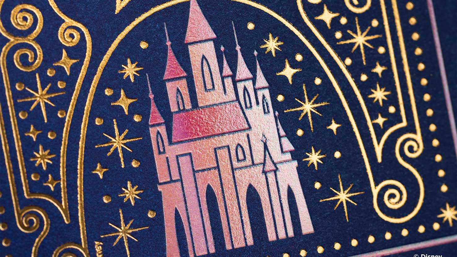 Nahaufnahme von glänzendem Disney-Schloss auf blauer Kartenschachtel. Disney Geschenke, Bicycle Spielkarten