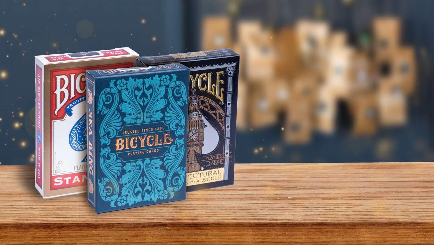 Die Bicycle Creatives Spielkarten Sea King und Architectural wonders of the world, so wie das Bicycle Originals Gold Standard Rot Deck stehen vor einem Adventskanlender auf einem Untergrund aus Holz und eignen sich hervorragend dazu einen Adventskalender selbst zu befüllen.