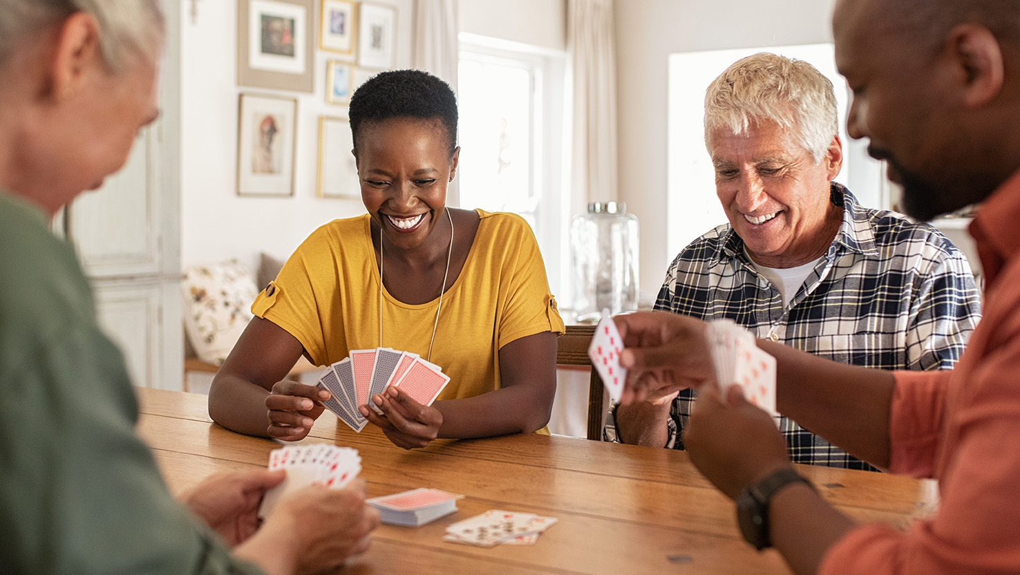 Eine Familie spielt Karten und stärkt dadurch ihre mentale Gesundheit.