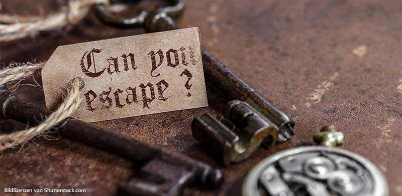 Zwei alte Schlüssel und eine Uhr liegen im Escape Room auf Tisch. Dazu ein Schild mit der Aufschrift Can You Escape. Rätsel für Erwachsene, ASS Altenburger