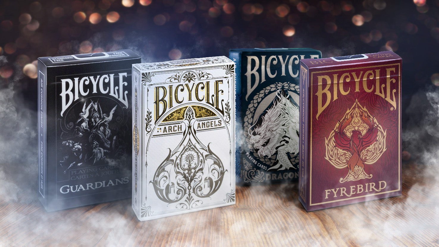 Die Bicycle Creatives Kartendecks Archangels, Dragons, Guardians und Fyrebird stehen vo einem nebligem und mystischem Hintergrund.