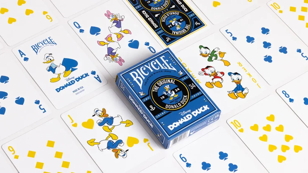 Kartenspiel Bicycle Disney Donald Duck liegt auf weißem Untergrund umgeben von Spielkarten. Donald Duck Bilder, Bicycle Spielkarten