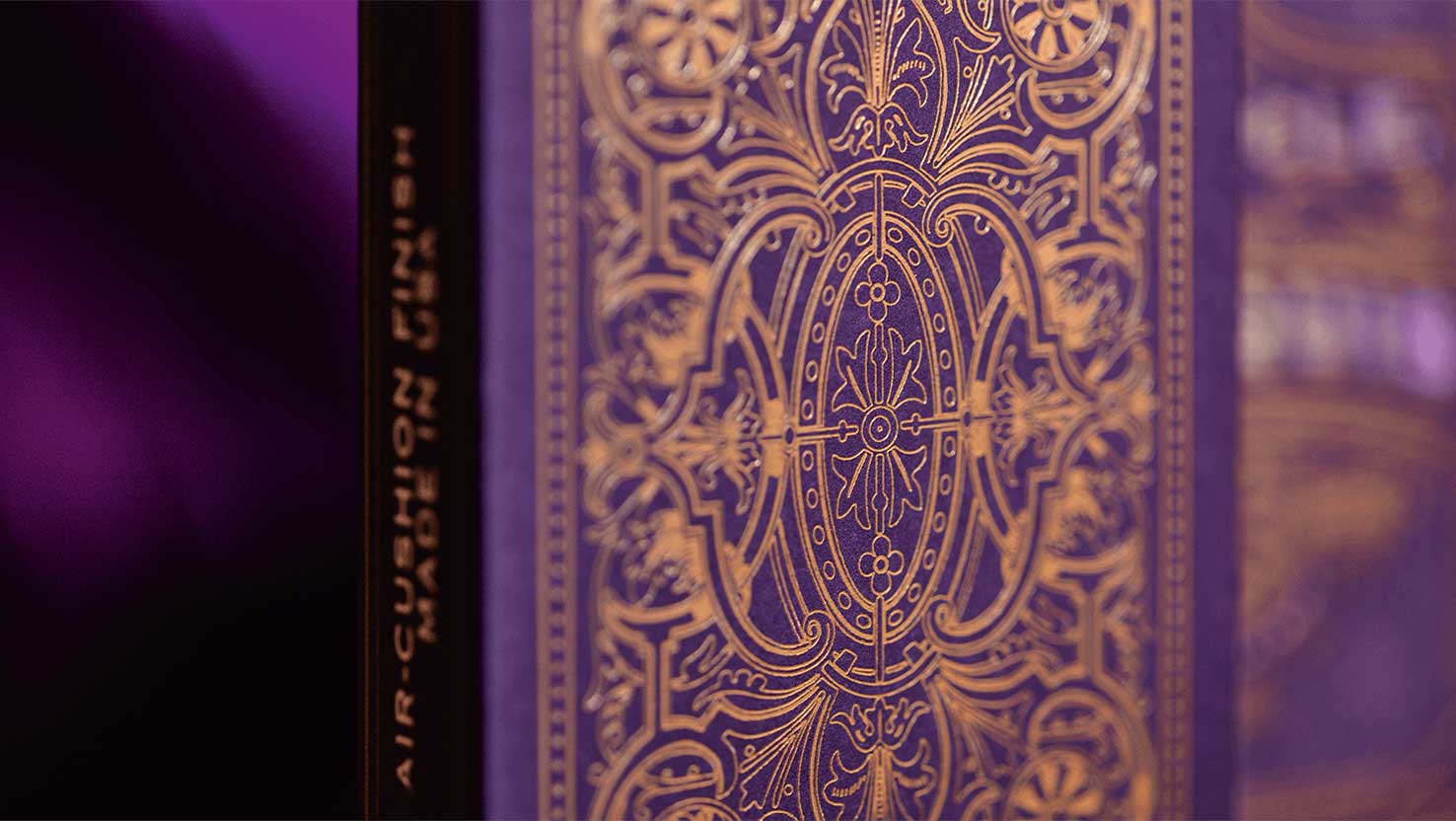 Nahaufnahme von goldenem Art Deco Muster auf violetter Kartenschachtel. Art Deco, Bicycle Spielkarten
